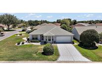 Charming single-story home featuring a well-manicured lawn and a decorative driveway at 1902 Del Norte Dr, Lady Lake, FL 32159