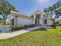 Charming single-story home featuring a manicured lawn, decorative rock landscaping, and a welcoming entryway at 21707 Queen Mary Ct, Leesburg, FL 34748