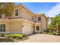 Charming two-story home with a neutral color scheme, a tile roof, brick driveway, and a manicured front yard at 26207 Avenida Las Colinas # 26207, Howey In The Hills, FL 34737