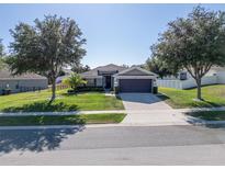 Charming single-story home with a well-manicured lawn, mature trees, and a two-car garage at 274 Giovani Blvd, Clermont, FL 34715