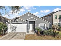 Charming single Gathering home featuring well-maintained landscaping and an attached two-car garage at 308 Anorak St, Groveland, FL 34736