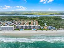 Stunning aerial view of beachfront condos, pool, and ocean, offering luxurious coastal living at 4435 S Atlantic Ave # 114, Ponce Inlet, FL 32127