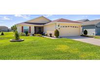 Charming home with a well-manicured lawn and colorful flower beds at 4671 Spring Grove Ln, Leesburg, FL 34748