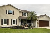 Charming two-story home featuring a well-manicured lawn, complemented by a side-entry garage and stone accents at 4941 Tradition Dr, Lakeland, FL 33812