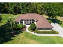 Aerial view of a single-Gathering home with a well-manicured lawn and mature trees at 5306 Greens Dr, Lady Lake, FL 32159