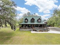 Charming home with a wraparound porch and a well-maintained lawn on a beautiful sunny day at 8091 C 476B, Bushnell, FL 33513