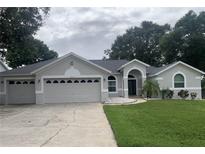 Charming single-story home with a three car garage, fresh landscaping, and inviting curb appeal at 14421 Pine Cone Trl, Clermont, FL 34711