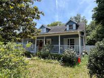 Charming blue two-story home with a cozy front porch and dormer windows at 1920 Baxter Ave, Orlando, FL 32806