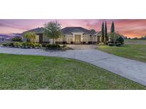 Stunning single-story home featuring well-manicured landscaping, a circular driveway, and a grand entrance at 41522 Saddle Ridge Ln, Weirsdale, FL 32195