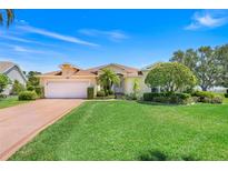 Beautiful one-story home with a manicured lawn, mature landscaping, and an attached two-car garage at 4720 Summerbridge Cir, Leesburg, FL 34748