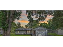 Charming single story home featuring a gray exterior, mature landscaping, and carport at 5011 Se 33Rd Ave, Ocala, FL 34480