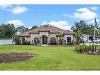 Stunning single-story home featuring a tile roof, well-manicured lawn, and lush landscaping at 16200 E Shirley Shores Rd, Tavares, FL 32778