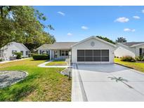 Charming home with a well-manicured lawn, screened garage, and inviting curb appeal at 917 Camino Del Rey Dr, Lady Lake, FL 32159