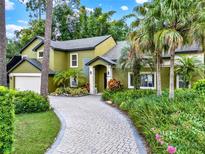 Charming two-story home featuring lush landscaping and a brick driveway at 9642 Bear Lake Rd, Apopka, FL 32703