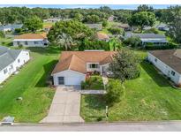 Inviting single-story home with well-maintained lawn and mature trees, featuring a two-car garage and neutral color palette at 9757 Se 175Th Pl, Summerfield, FL 34491