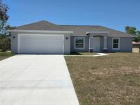 Well-maintained home with an attached two-car garage and a long concrete driveway at 15010 Sw 29Th Ave Road, Ocala, FL 34473