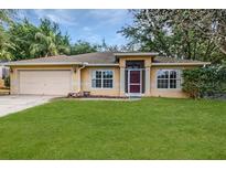 Charming single-story home featuring well-kept landscaping and a welcoming facade with a neatly manicured lawn at 1307 Rain Forest Ln, Minneola, FL 34715