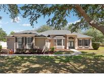 Charming single-story home with well-manicured lawn and inviting double-door entrance at 13301 Biscayne Dr, Grand Island, FL 32735