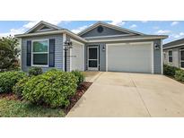 Charming single-Gathering home showcasing a two-car garage, manicured landscaping, and a welcoming entrance at 1486 Joshua Ct, The Villages, FL 32163