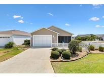 Charming home featuring a garage, screen room, white picket fence, and well-manicured landscaping at 1486 Olympia St, The Villages, FL 32163