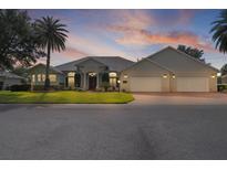 Lovely single-story home boasts a three-car garage, lush lawn, and well-maintained landscaping at 1721 Sunset Ridge Dr, The Villages, FL 32162