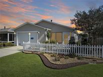 Charming single-story home with a well-manicured lawn, tasteful landscaping and white picket fence at 2449 Kingstree Pl, The Villages, FL 32162