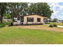Charming single-story home features a screened-in porch and a well-maintained front yard with mature landscaping at 24802 Pine Hl, Leesburg, FL 34748