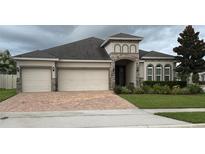 Charming single-story home featuring a three-car garage, brick driveway, and well-maintained landscaping at 2504 Cavender Creek Rd, Minneola, FL 34715
