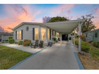 Well-maintained single-story home with a covered carport, beautiful landscaping, and charming curb appeal at 1109 Paradise Dr, The Villages, FL 32159
