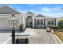 Charming single-story home featuring a cozy front patio and lush landscaping at 1140 Eureka Mill Run, The Villages, FL 32162