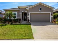 Charming home with a two-car garage, well manicured landscaping and green lawn at 13304 Magnolia Valley Dr, Clermont, FL 34711
