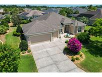 Lovely single-story home featuring a well-manicured lawn, neutral paint scheme, and a spacious driveway and attached garage at 1842 Lake Ridge Dr, The Villages, FL 32162