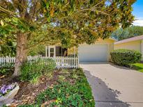 Charming single-story home featuring a well-maintained yard, lovely landscaping, and a welcoming two-car garage at 2102 Estevez Dr, Lady Lake, FL 32159