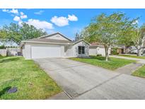 Charming single-story home featuring a well-manicured lawn and two car garage at 2136 Fish Eagle St, Clermont, FL 34714
