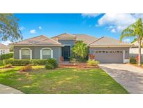 Charming one-story home featuring a tile roof, well-maintained landscaping, and a paved driveway leading to an attached garage at 2641 Meadow View Ct, Kissimmee, FL 34746
