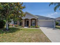 Charming home featuring stone accents, a well-manicured lawn, and a two-car garage at 31920 Parkdale Dr, Leesburg, FL 34748
