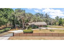 Charming single-story home with beautiful mature trees, a basketball court, and a fenced yard at 32132 Hickory Ln, Sorrento, FL 32776