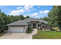 Beautiful single-story home featuring stone accents, a spacious two-car garage, and meticulously landscaped front yard at 562 Dowling Cir, Lady Lake, FL 32159