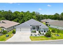 Beautiful single-story home featuring a three-car garage and meticulously manicured landscaping at 6988 Lawrenceville Way, The Villages, FL 34762