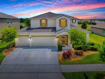 Charming two-story home featuring a three-car garage, well-manicured lawn, and tasteful landscaping at 718 Lake Douglas Dr, Groveland, FL 34736