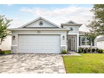 Charming single-story home with a paver driveway, two-car garage, and well-maintained landscaping at 8492 Hartford Way, Mount Dora, FL 32757