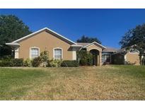 Inviting single-story home with stucco exterior, manicured landscaping, and a well-maintained front lawn at 11301 Via Mari Cae Ct, Clermont, FL 34711