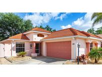Charming single-Gathering home featuring a red tile roof, landscaped front yard, and attached two-car garage at 1305 Santa Maria Ave, The Villages, FL 32159