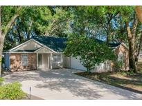 Charming single-story home featuring stone accents, a well-manicured yard, and a concrete driveway leading to an attached garage at 1663 Markel Dr. Dr, Winter Garden, FL 34787