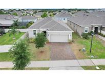 Charming single-story home with a well-maintained lawn and a brick-paved driveway at 169 Jensen Dr, Groveland, FL 34736
