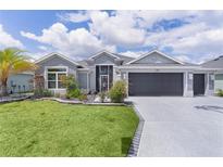 Beautiful single Gathering home with a well manicured lawn and landscaping with a two car garage at 2129 Landrea Loop, The Villages, FL 32163