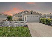 Charming single story home with well-manicured lawn, picket fence, and inviting curb appeal at 2296 Whisper St, The Villages, FL 32162