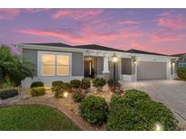 Charming single-story home with landscaped front yard and a two-car garage at 560 Caputo Ct, The Villages, FL 32163