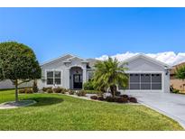 Beautiful single story home with well-manicured landscaping and a charming front yard at 5818 Greenbriar Loop, Leesburg, FL 34788