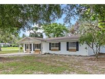 Charming single-story home featuring a covered front porch and black window shutters at 6808 Fern Cir, Leesburg, FL 34748